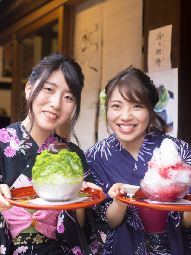 Happy sisters in Yukata holding Kakigori ice dessert at cafe
