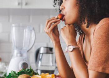 Shot of a young woman making a healthy snack with fruit at home
