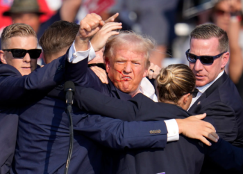 Former President Donald Trump forced Secret Service agents to pause before rushing him off stage following a possible assassination attempt at a rally in Butler, Pennsylvania, on Saturday. In a defiant gesture, Trump pumped his fist and repeated the word “fight.”