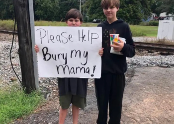 Lindale, Georgia: Boy holds sign to raise funds for mother’s funeral