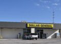 A Dollar General store with its yellow and black sign, a white SUV parked out front, in Sapulpa, Oklahoma