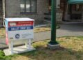 A white, red and blue Pierce County ballot drop box on the lawn outside the stone Town Hall in Wilkeson, Washington