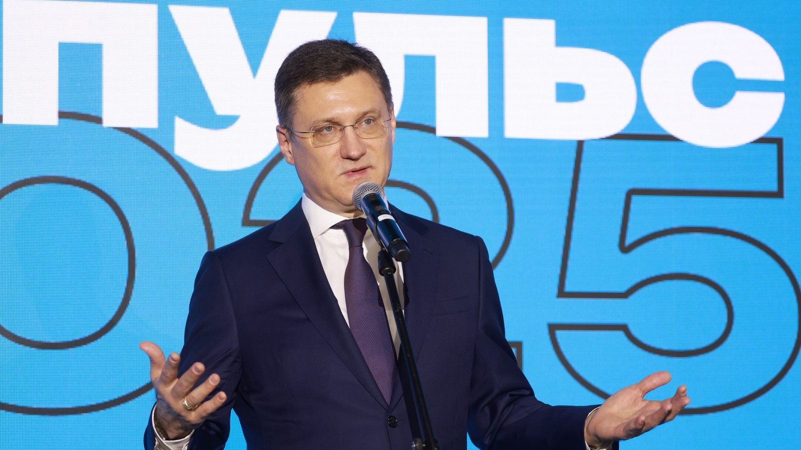Russian Deputy Prime Minister Alexander Novak speaking into a microphone on stage in Moscow