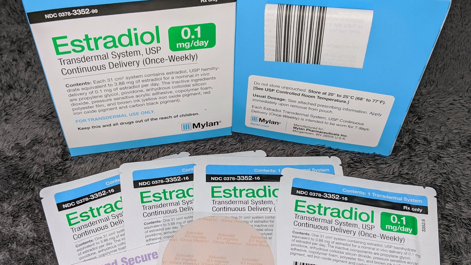 Boxes and foil pouches of generic once-weekly estradiol transdermal patches made by Mylan, with a round patch partly visible in front