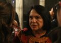 Dolores Huerta, in a dark blouse with red and gold embroidery, talks with students after a human rights keynote at the University of Chicago