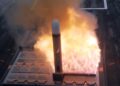 A Tomahawk cruise missile rises in a burst of flame from a launch cell on the deck of a US Navy destroyer