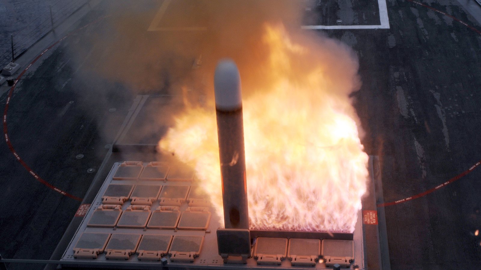 A Tomahawk cruise missile rises in a burst of flame from a launch cell on the deck of a US Navy destroyer