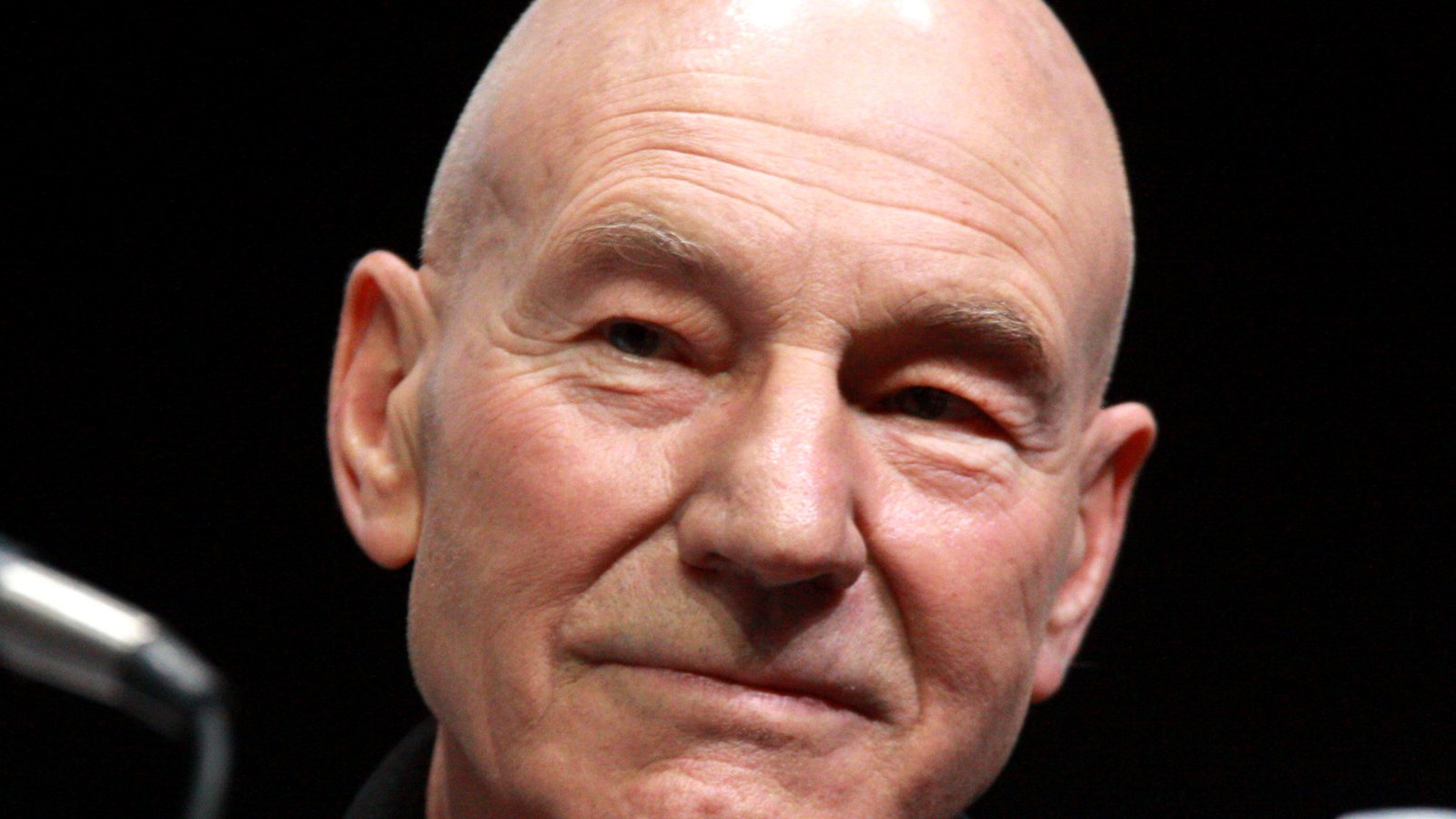Close-up of Patrick Stewart smiling slightly while seated at a panel at San Diego Comic-Con in 2013