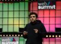 Kalshi co-founder Tarek Mansour in a black hoodie speaking on stage in front of a lit Web Summit backdrop
