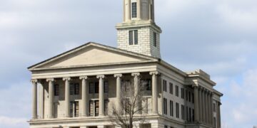The Tennessee State Capitol in Nashville, a columned limestone building with a central tower, under a cloudy sky
