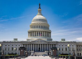 The US Capitol dome and east front seen across the plaza under a blue sky in Washington