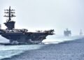 US Navy aircraft carrier USS Dwight D. Eisenhower leads a supply ship and a destroyer through the Strait of Hormuz