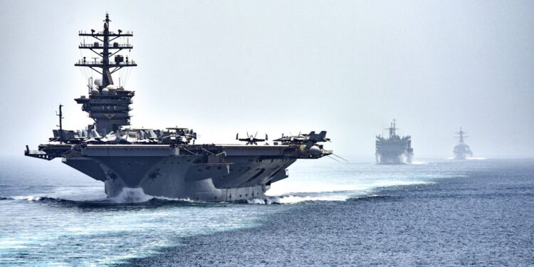 US Navy aircraft carrier USS Dwight D. Eisenhower leads a supply ship and a destroyer through the Strait of Hormuz