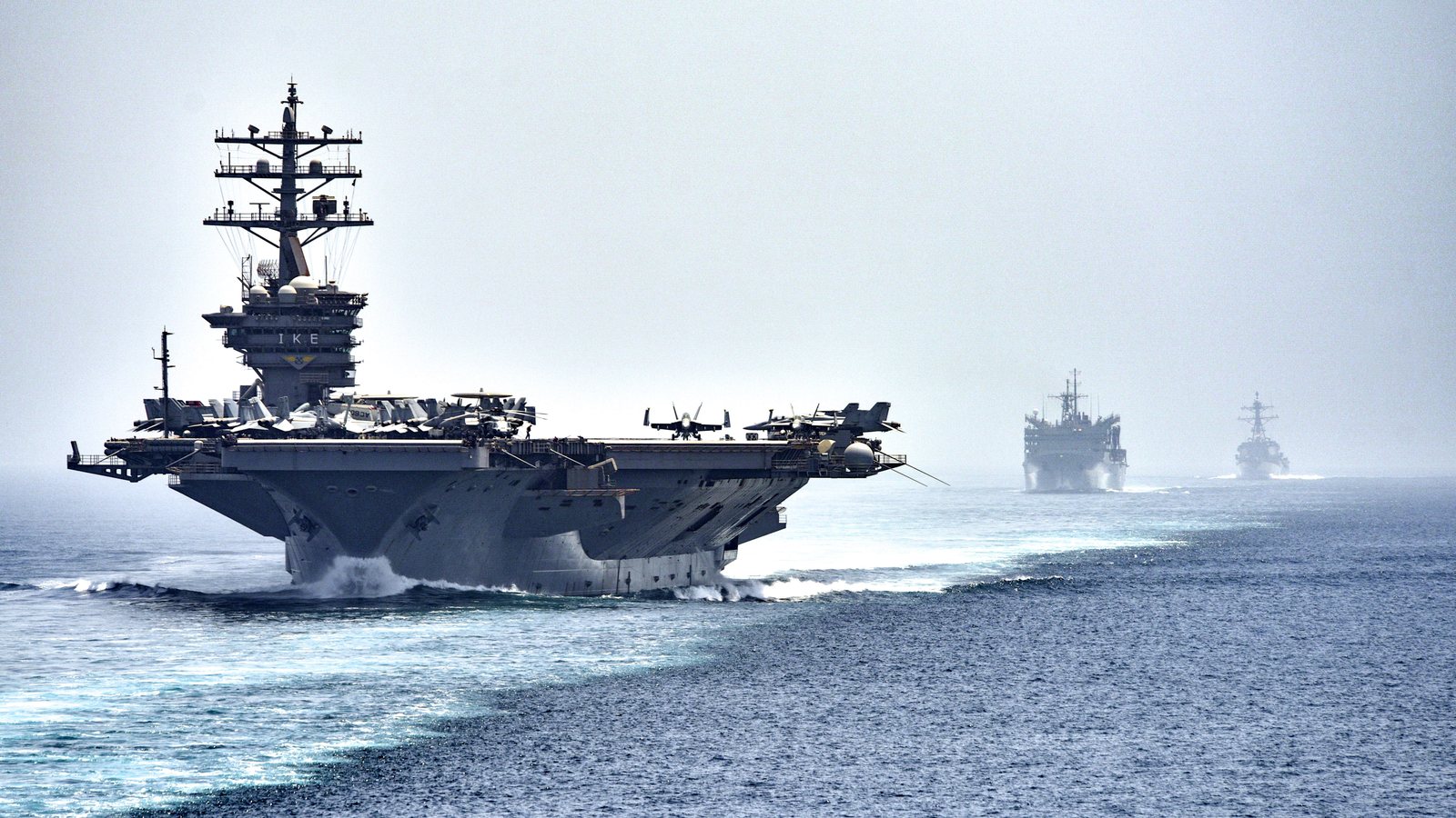 US Navy aircraft carrier USS Dwight D. Eisenhower leads a supply ship and a destroyer through the Strait of Hormuz