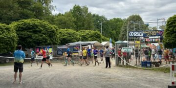 Runners set off on a new hourly loop under an O-SEE Backyard Ultra banner in Zittau, Germany