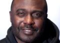 Marshall Faulk, smiling, in a black hooded sweatshirt at an event in Scottsdale, Arizona, in 2023