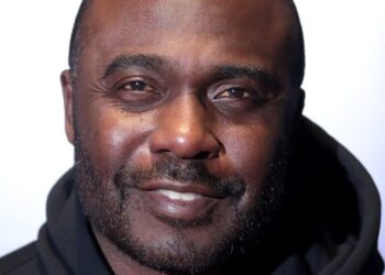 Marshall Faulk, smiling, in a black hooded sweatshirt at an event in Scottsdale, Arizona, in 2023