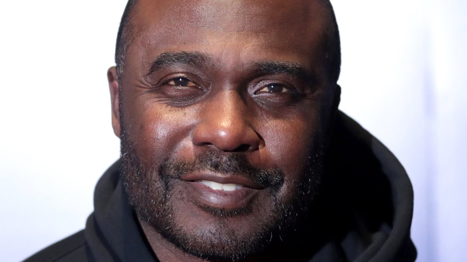 Marshall Faulk, smiling, in a black hooded sweatshirt at an event in Scottsdale, Arizona, in 2023