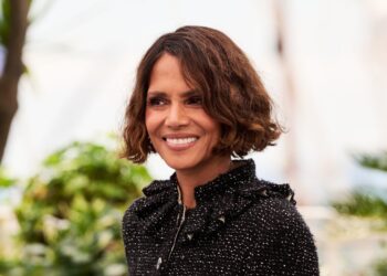 Halle Berry, with short wavy hair and a black tweed jacket, at a daytime photocall in Cannes