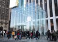 Shoppers walk past the glass cube entrance of Apple's Fifth Avenue store in New York