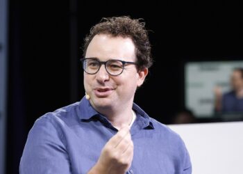 Anthropic chief executive Dario Amodei, in a blue shirt and glasses, speaking on stage at TechCrunch Disrupt