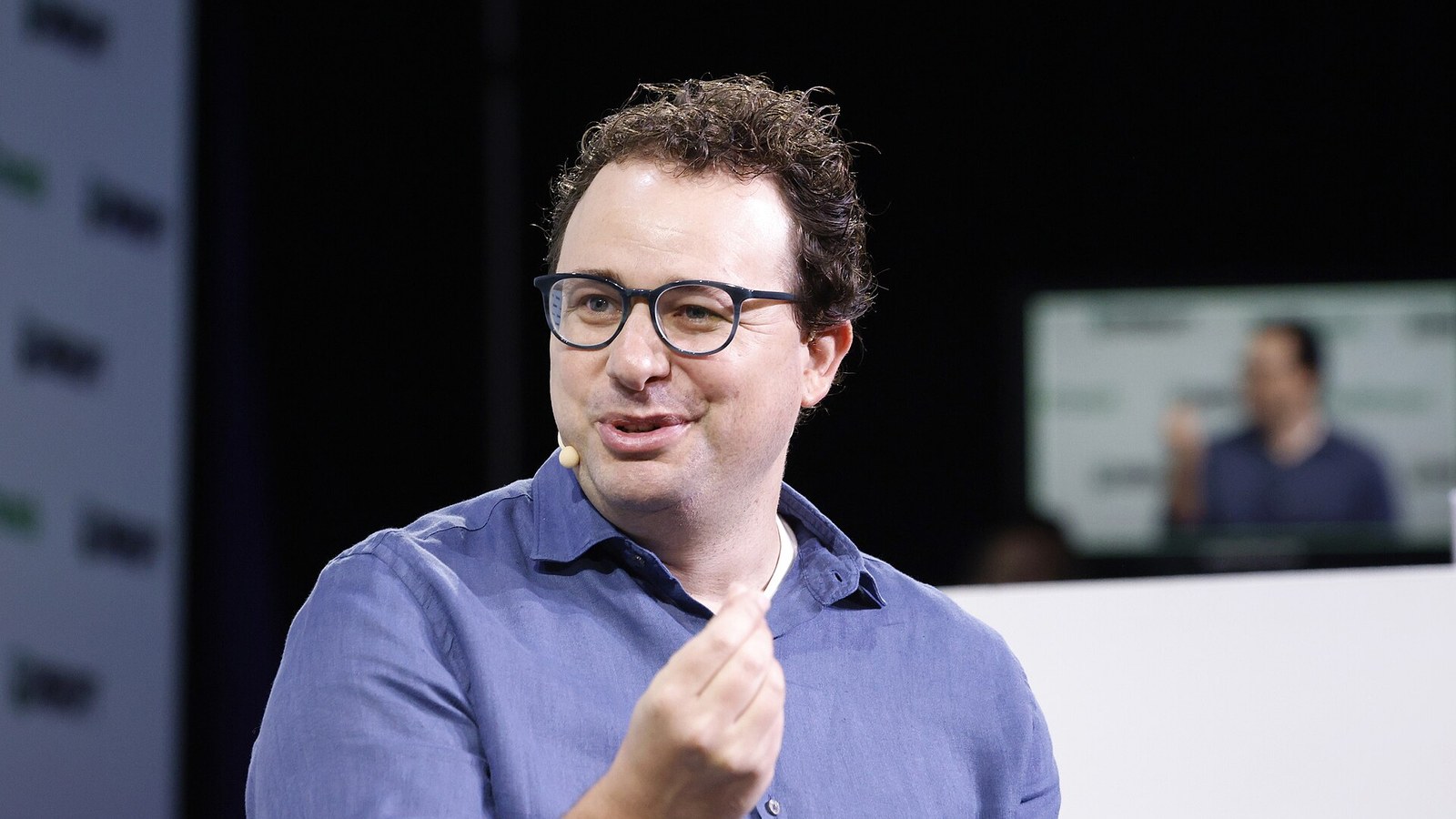 Anthropic chief executive Dario Amodei, in a blue shirt and glasses, speaking on stage at TechCrunch Disrupt