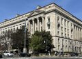 The Robert F. Kennedy Department of Justice Building in Washington, D.C., seen from a street corner on a clear day