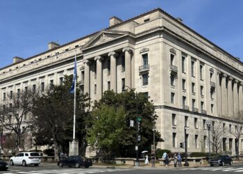The Robert F. Kennedy Department of Justice Building in Washington, D.C., seen from a street corner on a clear day