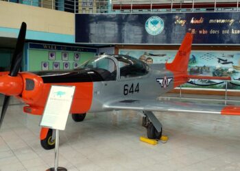 A silver and orange Philippine Air Force SF-260 trainer aircraft on display indoors at the PAF Aerospace Museum