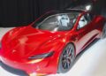 Red Tesla Roadster prototype parked on a white floor at Tesla headquarters