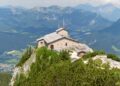 The stone Kehlsteinhaus, or Eagle's Nest, on a forested ridge above Berchtesgaden with Alpine peaks behind