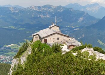 The stone Kehlsteinhaus, or Eagle's Nest, on a forested ridge above Berchtesgaden with Alpine peaks behind