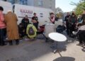 Residents of Kupiansk, Ukraine, charge and use their phones around a Starlink satellite dish set up on a street beside a white van