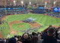 Fans in the upper deck at Tropicana Field watch the Rays' American League championship trophy ceremony on the infield, with American League Champions graphics on the stadium video boards