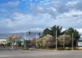 Meta's 1 Hacker Way headquarters sign beside a road intersection in Menlo Park, California, under a cloudy sky