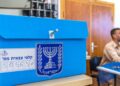 A blue Israeli ballot box with the state emblem and a numbered label on a counter at a military polling station