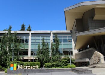 The Microsoft logo sign in front of Building 92 on the company's campus in Redmond, Washington, under a clear blue sky
