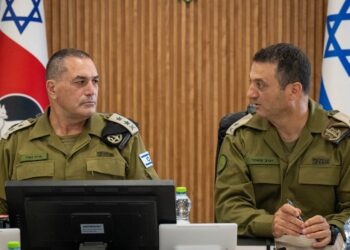 Israeli army chief Eyal Zamir, in olive uniform, sits at a conference table beside another senior officer, with Israeli flags behind them