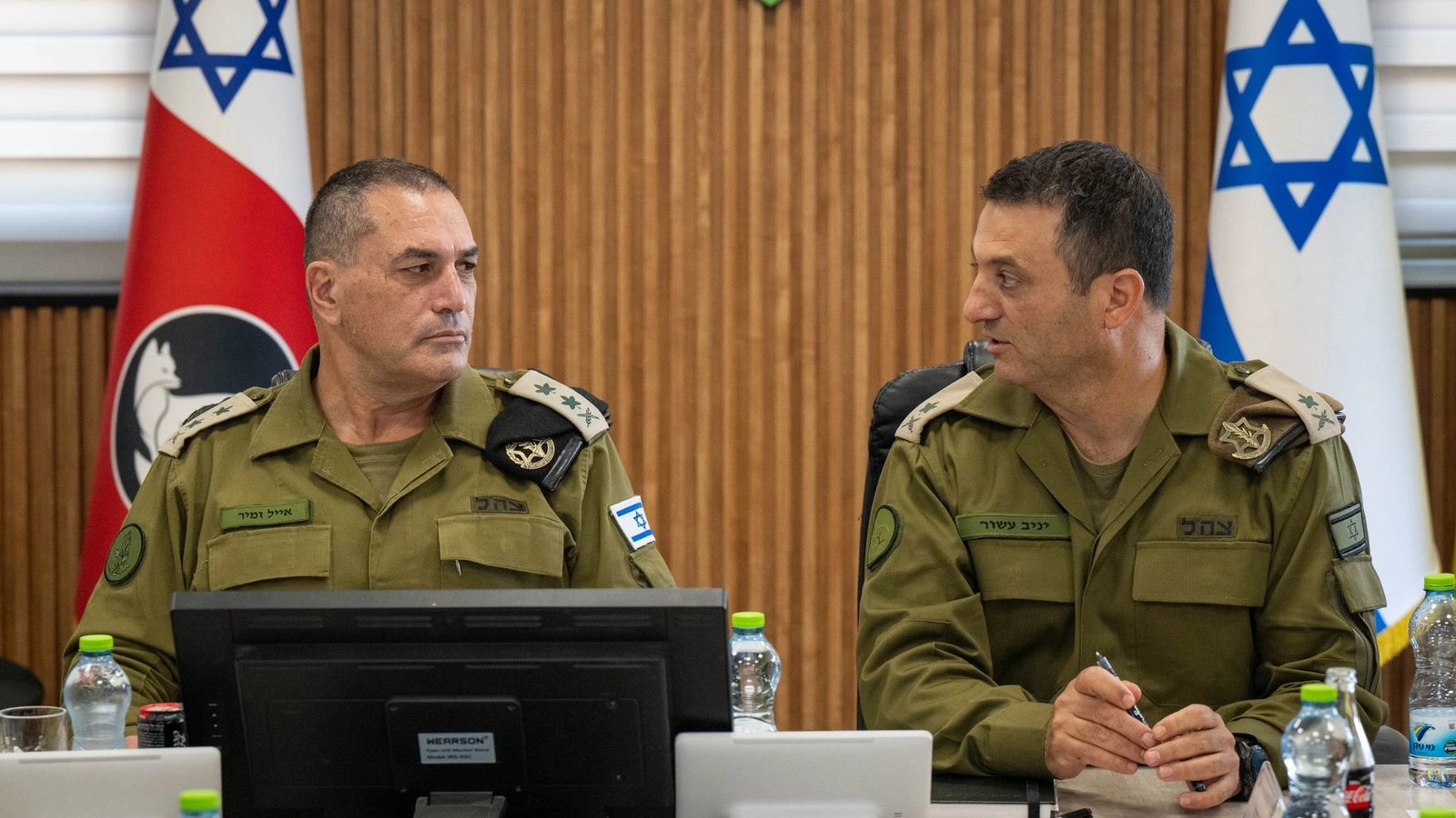 Israeli army chief Eyal Zamir, in olive uniform, sits at a conference table beside another senior officer, with Israeli flags behind them