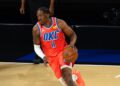 Oklahoma City Thunder forward Jalen Williams, in an orange OKC jersey, dribbles the ball up the court during an NBA Cup game