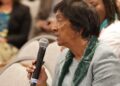 Navi Pillay speaking into a microphone at a panel